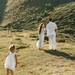 A family enjoys a sunny day on a grassy hillside, capturing the essence of outdoor leisure and connection.