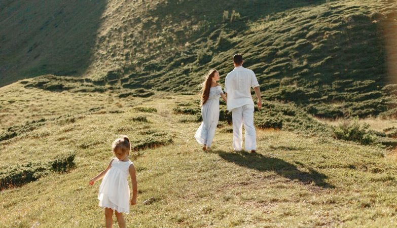 A family enjoys a sunny day on a grassy hillside, capturing the essence of outdoor leisure and connection.